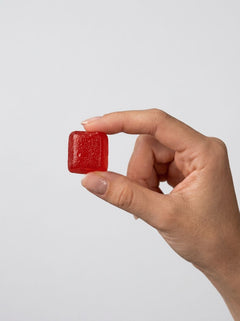 GoodHead Salivating Flavoured Oral Play Dry Mouth Gummies 3-Pack red watermelon gummy held between fingertips for scale