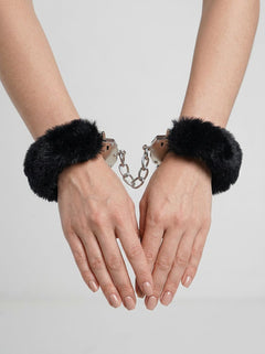 Me You Us Fluffy Quick Release Handcuffs - luxurious black fluffy cuffs displayed on hands, featuring comfortable faux fur trim and a metal chain.