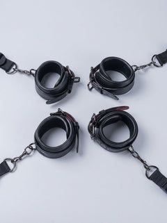 Luxury Faux Leather Bondage Bed Restraint Kit featuring four black adjustable cuffs with chains and straps, bed restraint accessories