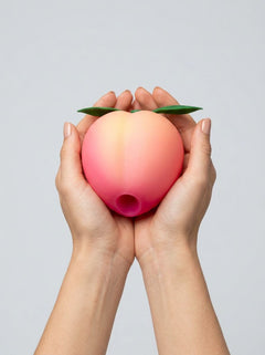 Romp Pink Peach silicone clitoral vibrator with suction feature, designed for targeted stimulation and pleasure.