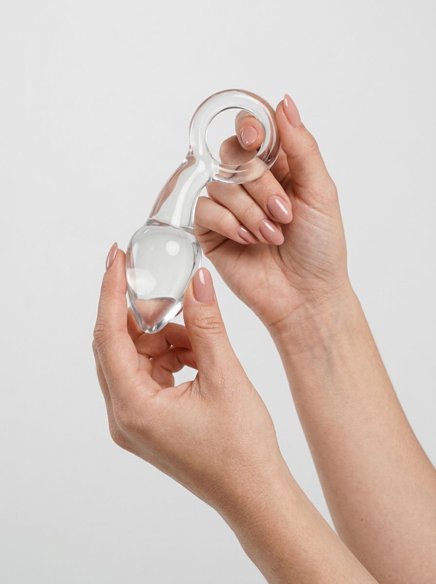 Clarity Utopian Delight 3.5 Inch Glass Butt Plug held in hands, showing its smooth polished glass design and flared base