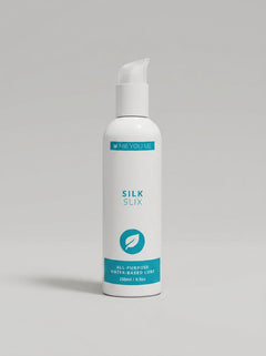 Me You Us Silk Slix Water Based Lubricant Pump Bottle White 250ml against a decorative background, conveying an essence of luxury and comfort in intimate moments.