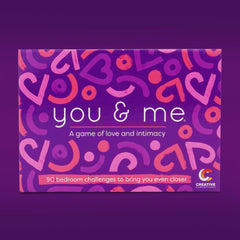 Gameplay scene from You & Me couples board game showcasing the exciting components including 90 forfeit cards and a die.