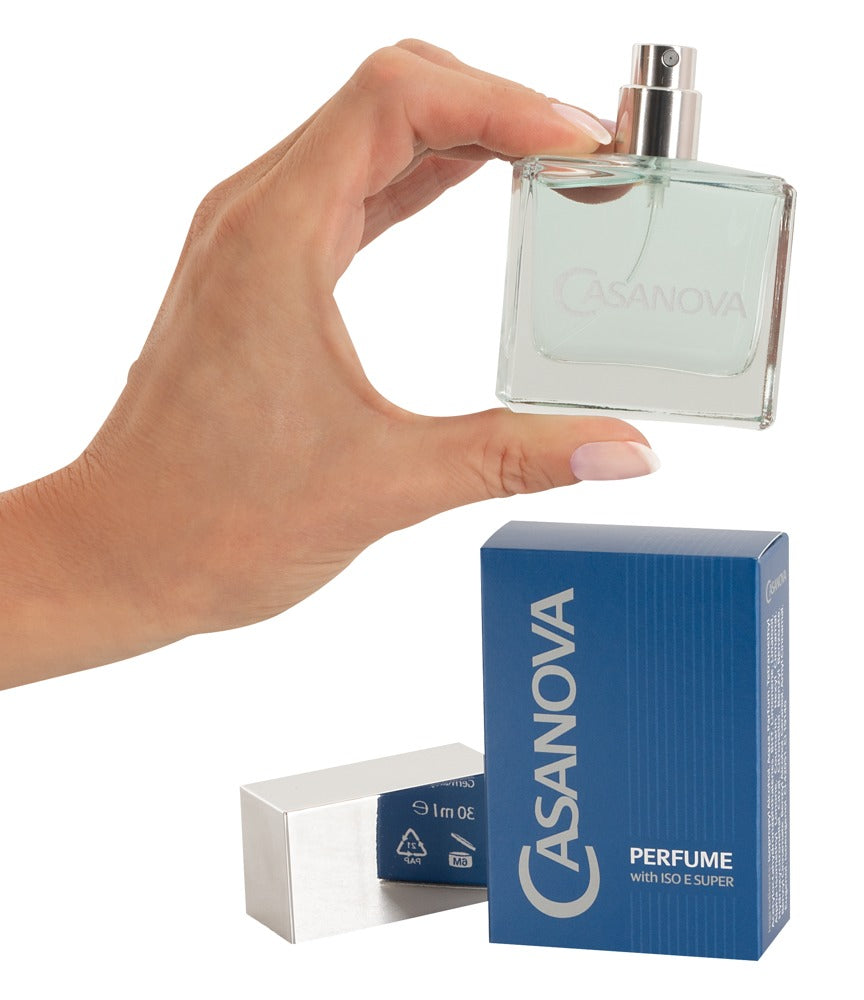 a hand holding a bottle of perfume next to a box