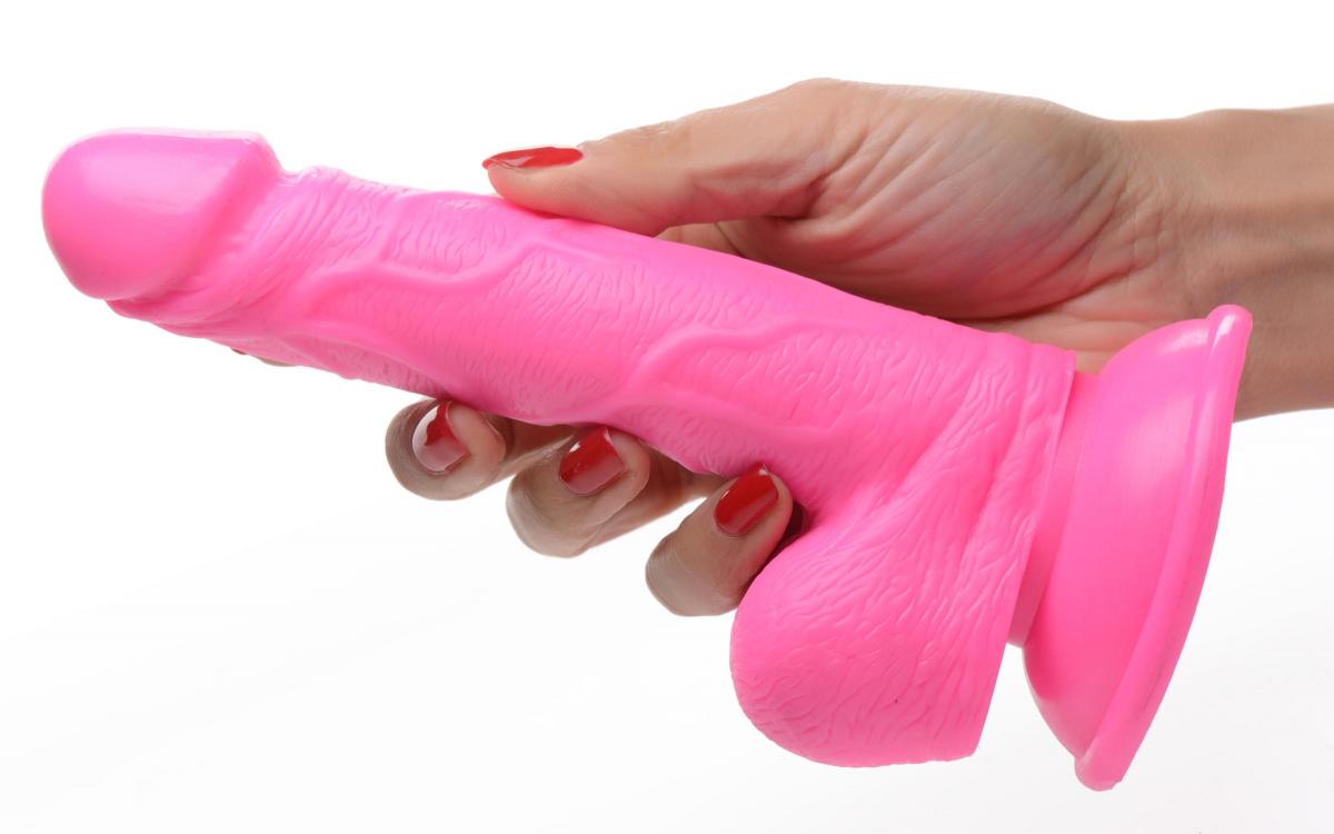 a woman's hand holding a pink plastic object
