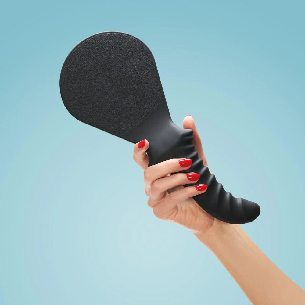 Fun Factory BÜCK DICH kinky spanking paddle with integrated dildo, black 2-in-1 whip and paddle for BDSM play and sensation.