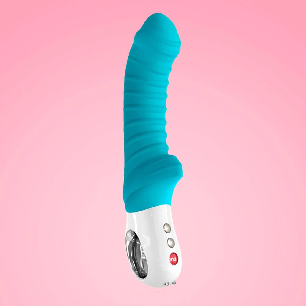 a blue and white vibrating device on a pink background