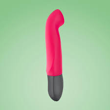 a pink vibrating device floating in the air on a green background