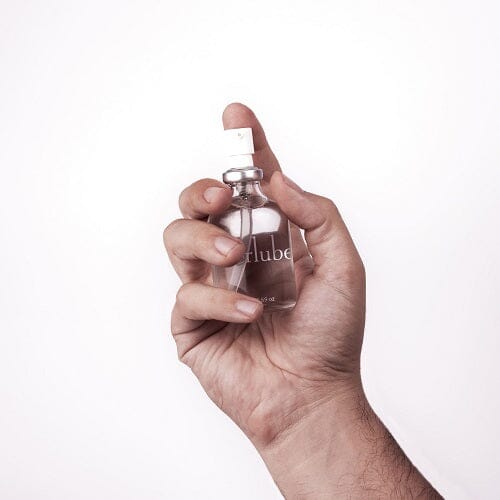a person holding a bottle of perfume in their hand