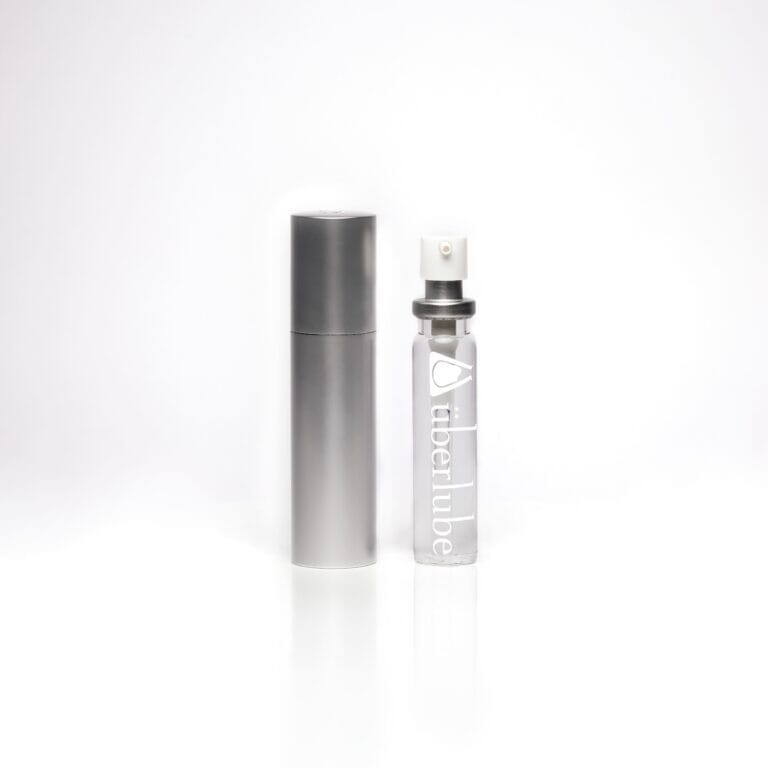 a bottle of perfume sitting next to a silver tube