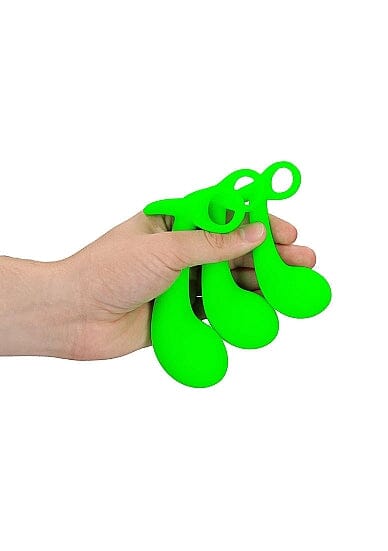 a hand holding a green pair of scissors